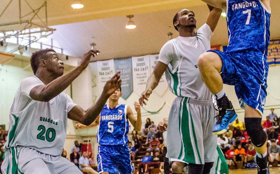 Faith Academy's T.J. Hardeman Jr. shoots over Kubasaki defenders DeQuan Alderman and Tristan McElroy during Thursday's championship game in the 66th Far East High School Boys Division I Basketball Tournament at Camp Foster, Okinawa.