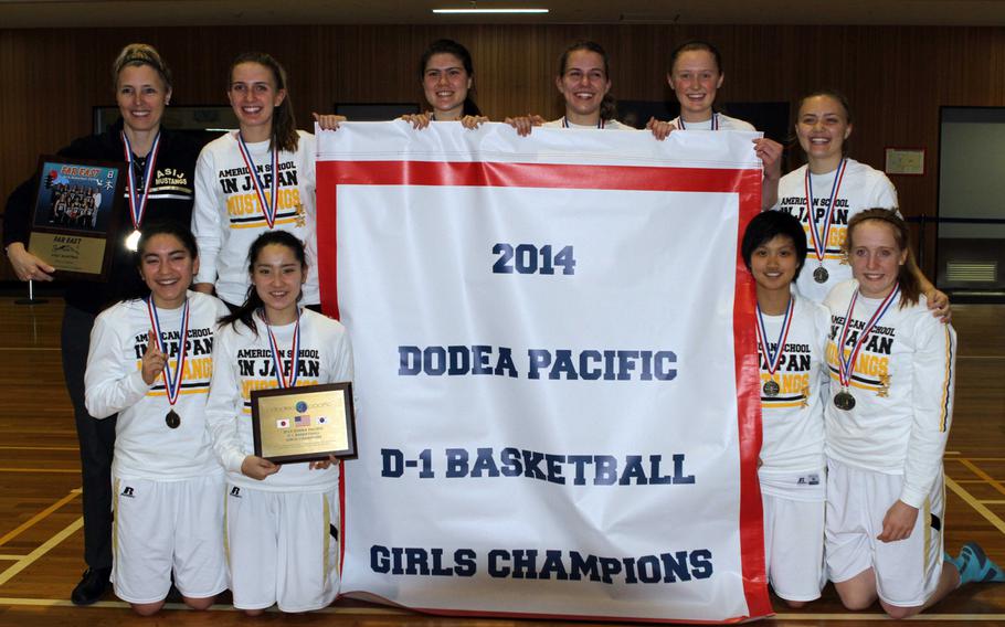 American School In Japan players and coach Julie Rogers, top left, gather 'round the banner after Thursday's championship game in the Far East High School Girls Division I Basketball Tournament at Camp Zama, Japan. ASIJ beat Kadena 57-37, ending a 22-year title drought.
