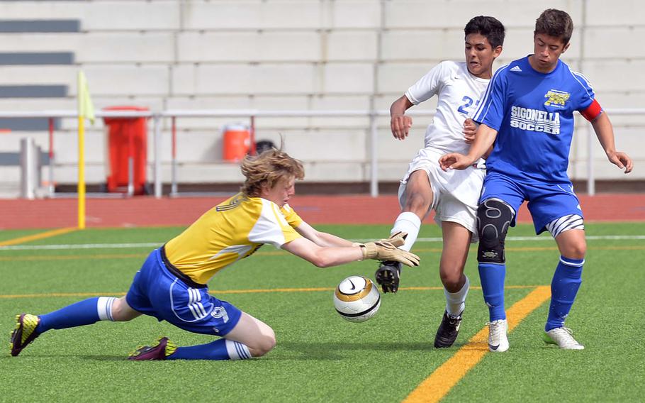 Sigonella keeper Thomas Wray plucks the ball from the foot of Brussels' Damien Escalante as teammate Patrick Gallagher watches. Sigonella beat Brussels 4-3 to take the Division III title at the DODDS-Europe soccer championships in Kaiserslautern, Germany, 22 May, 2014.