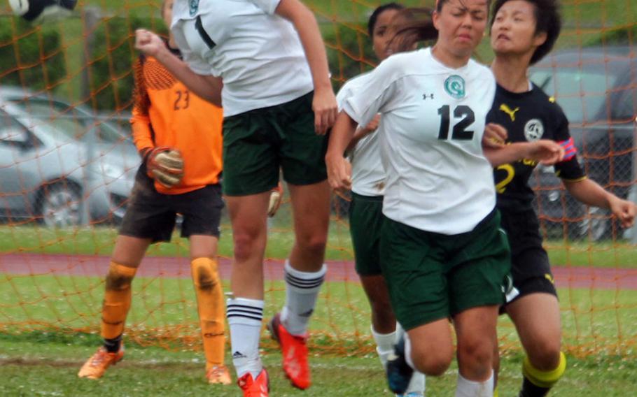 Kubasaki's Kelsey Spangenberger heads the ball in front of teammate Ami Eldridge and American School In Japan's Joey Yamada. The Dragons won Thursday's Far East Division I Tournament final in a penalty-kick shootout over the defending champion Mustangs.