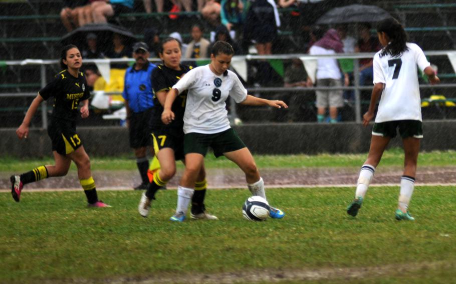 Kubasaki's Elizabeth Zuniga-Castaneda defends her position against American School in Japan's Andrea Yonamine at the Far East Division 1 girls soccer championship on Camp Foster, Okinawa, May 22, 2014. 