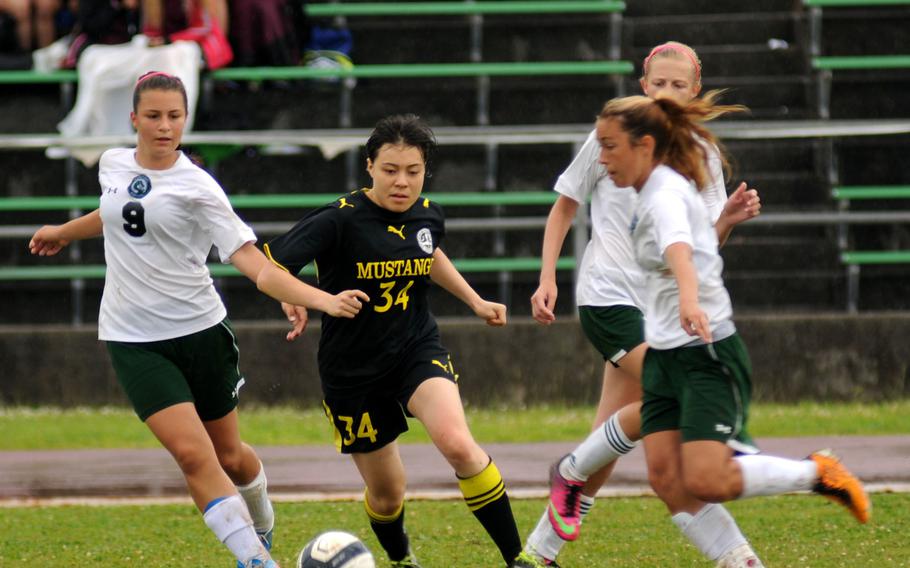 American School in Japan's Josephine Carroll attempts to push past the Kubasaki players at the Far East Division 1 girls soccer championship at Camp Foster, Okinawa, May 22, 2014.