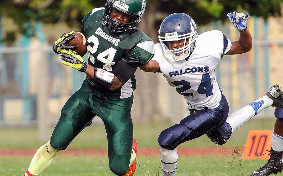 Kubasaki Dragons running back Jarrett Mitchell, shown playing against Seoul American's Myles Haynes in the 2013 regular-season finale, exits as Stars and Stripes Pacific high school boys Athlete of the Year and as Kubasaki's career leading rusher in the Far East playoff era.