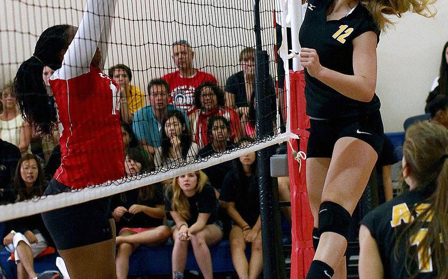 American School In Japan Mustangs junior middle blocker Mia Weinland, shown spiking against Nile C. Kinnick Red Devils junior middle blocker Audri Salter during the Far East High School Girls Division I Volleyball Tournament championship match on Nov. 7, 2013. ASIJ won its third straight title, Weinland earned MVP honors and is Stars and Stripes' Pacific high school girls Athlete of the Year.