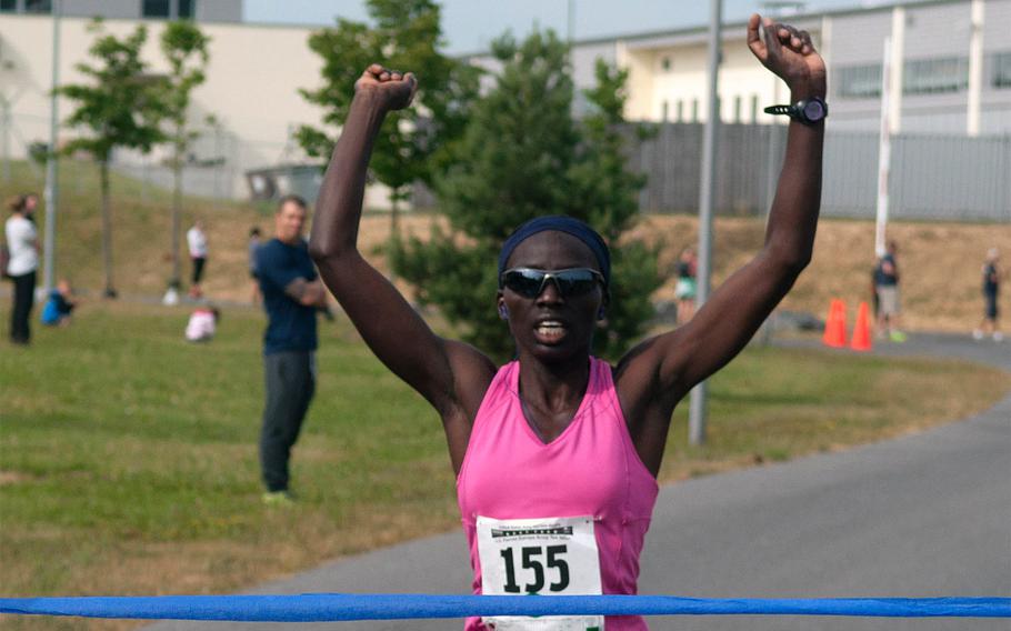 Spc. Caroline Jepleting crosses the finish line, winning the women's competition in the U.S. Forces Europe Army 10-Miler qualifier held at USAG Grafenwöhr, Germany, on Saturday, June 28, 2014. It was the first long-distance race in which Jepleting competed.