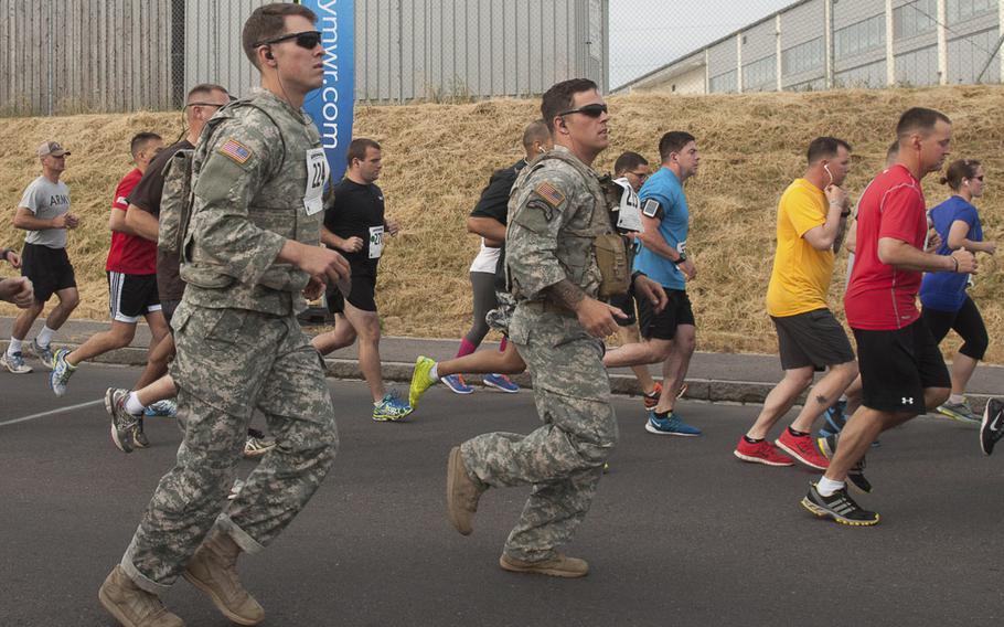 First Lt. Harrison Maxwell and Staff Sgt. Brandon Simmons run in full combat uniform on their way to finishing the U.S. Forces Europe Army 10-Miler qualifier held at USAG Grafenwöhr, Germany, on June 28, 2014.