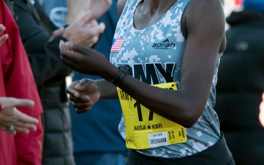 Army Spc. Caroline Jepleting crosses the finish line at the Pentagon Sunday morning as the top military finisher at the 2014 Army Ten-Miler. Jepleting also took second place in the women's division.