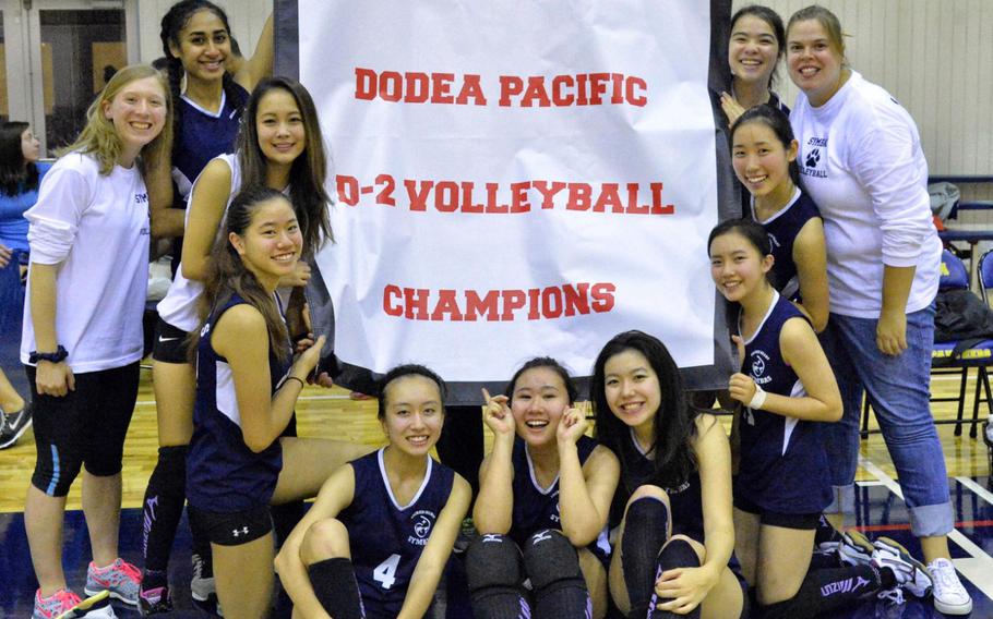 International School of the Sacred Heart Symbas players gather round the banner after winning the first Far East Division II girls volleyball tournament title in school history.