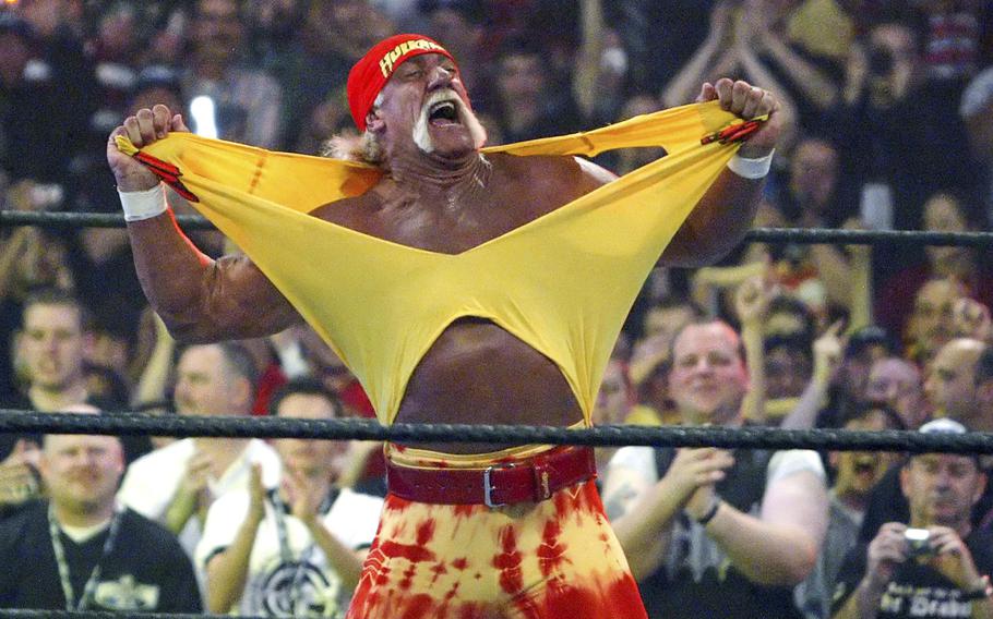 A man rips his shirt off in front of a crowd.