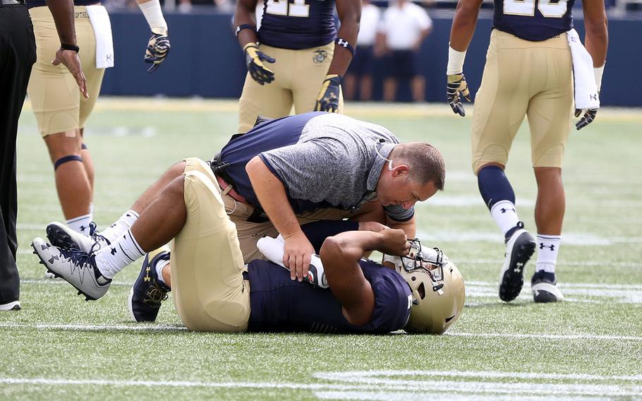 Navy's Tago Smith #2 is tended to by a trainer after suffering an injury against Fordham during an NCAA college football game on Saturday, Sept. 3, 2016, in Annapolis, Md. 