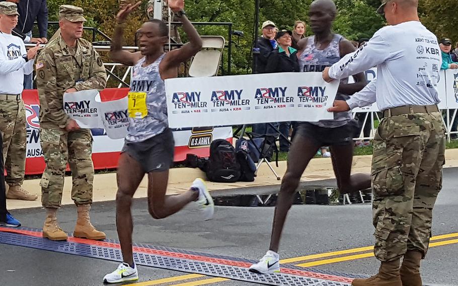 Army Sgt. Augustus Maiyo leads teammate Lt. Robert Cheseret across the finish line at the Army Ten-Miler, Oct. 9, 2016.