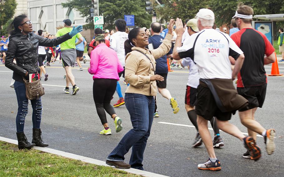 Runners give people cheering on the sidelines high-fives at the Army Ten-Miler in Washington, D.C., on Oct. 9, 2016.