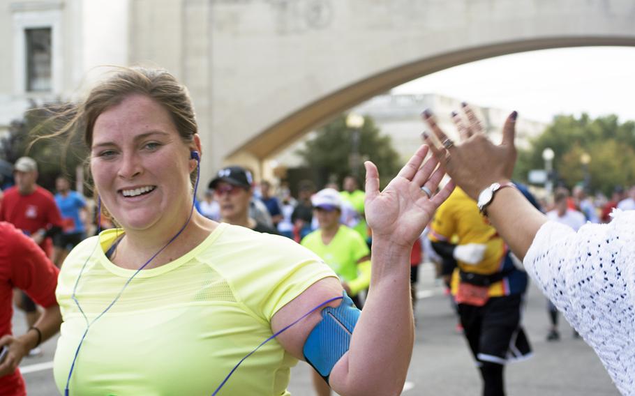 A runner gives a woman cheering on the sidelines a high-five at the Army Ten-Miler in Washington, D.C., on Oct. 9, 2016.