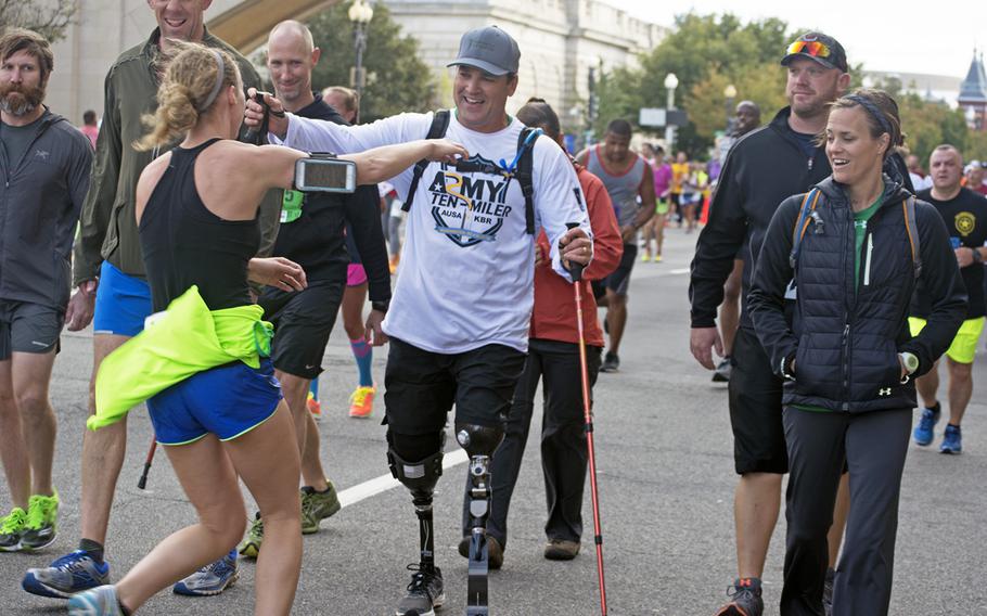 A runner, spying a friend among the participants, pauses her race to give a quick embrace at the Army Ten-Miler in Washington, D.C., on Oct. 9, 2016.