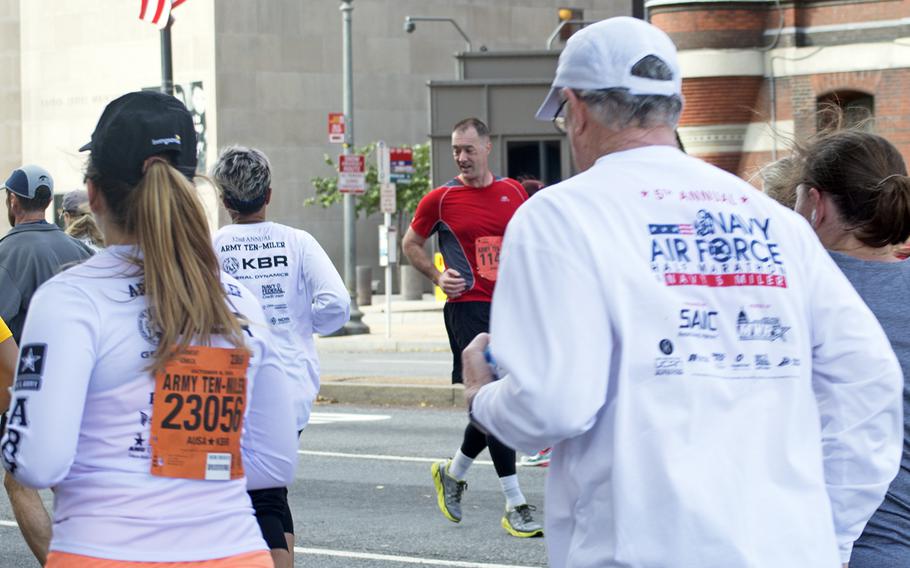 A runner in red jogs backwards during the Army Ten-Miler in Washington, D.C., on Oct. 9, 2016.