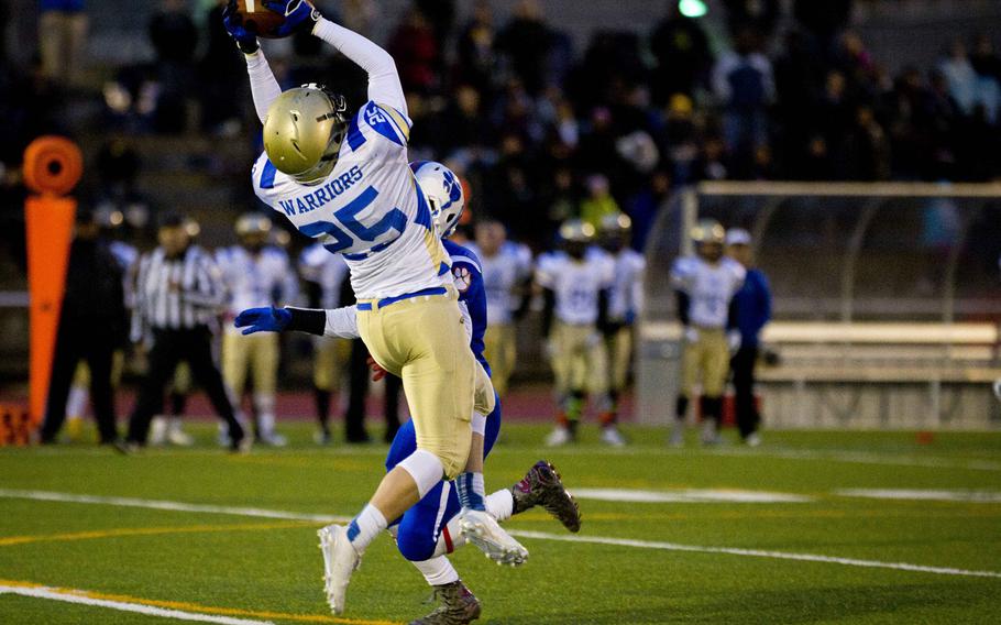 Wiesbaden's Allen Quitagua catches a pass over Ramstein's Brendan Hicks during the DODEA-Europe Division I championship at Vogelweh, Germany, on Saturday, Nov. 5, 2016. Wiesbaden lost 13-8.