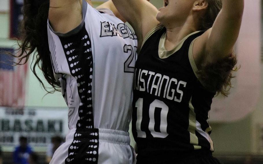 American School In Japan's Allie Rogers tries to block American School of Bangkok shooter Neeltje Hendriske during Wednesday's semifinal in the Far East Girls Division I Tournament. The Eagles pulled away late to beat the Mustangs 71-47; ASIJ had reached the finals the last four years.