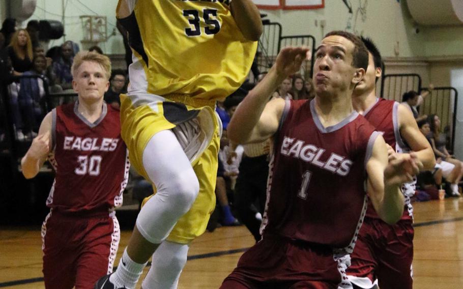 Kadena's Nick Laney goes up for a shot past American School of Bangkok's Jalen Lomax during Tuesday's semifinal in the Far East Boys Division I Basketball Tournament. The Panthers beat the Eagles 57-50 to reach the final for the third straight year.