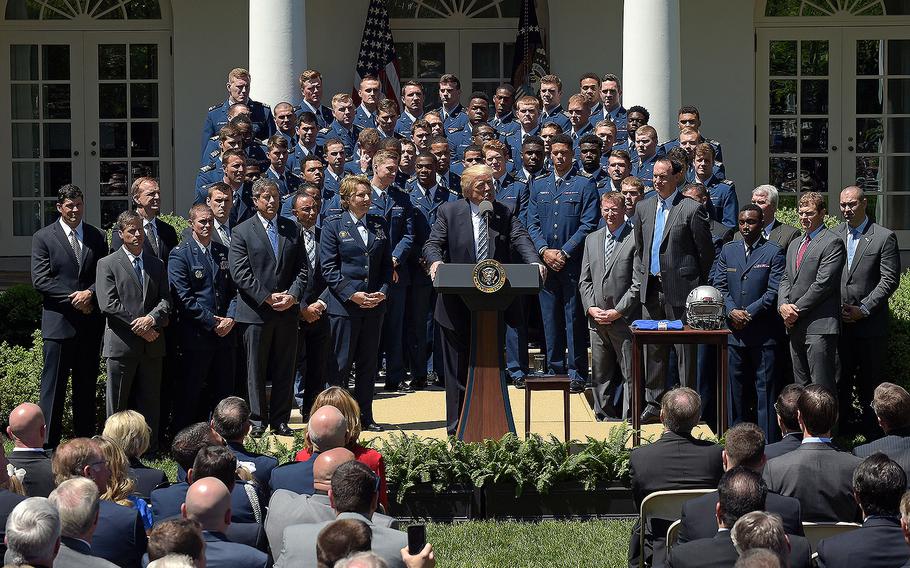 President Donald Trump, standing with the Air Force Academy football team, speaks in the Rose Garden of the White House in Washington, Tuesday, May 2, 2017, during a presentation ceremony of the Commander-in-Chief trophy to the team. 