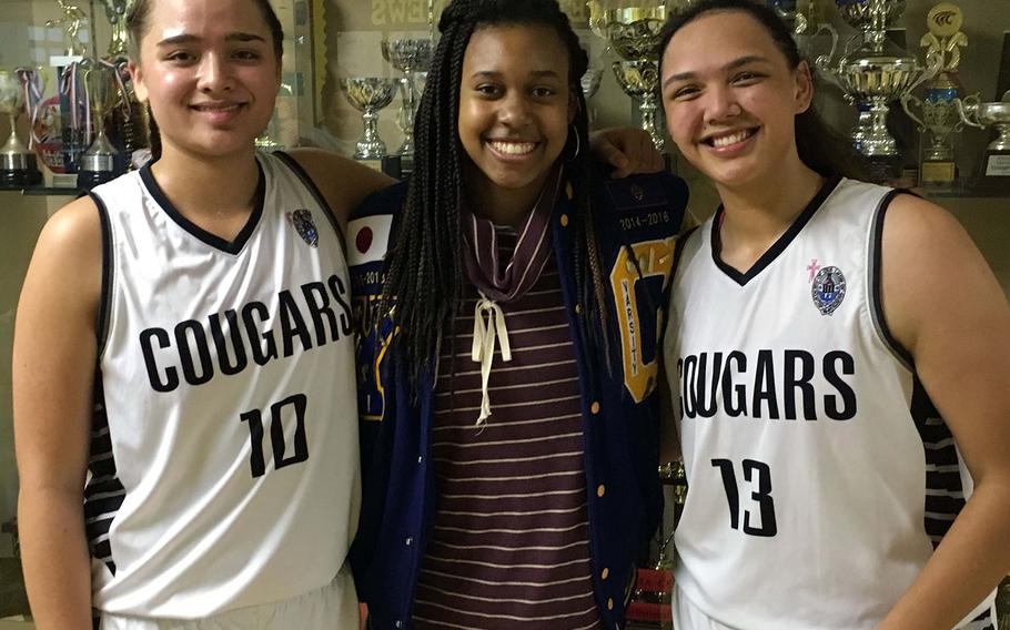 Rivals reuinted at the 2nd Kanto Classic Basketball Tournament. Academy of Our Lady of Guam's unanimous All-Island MVP Mia San Nicolas and teammate Meaghan "Mink" Cruz flank Yokota senior center Britney Bailey in front of the trophy case at American School In Japan. Bailey played against San Nicolas and Cruz frequently while with Guam High School in her freshman and sophomore seasons. Bailey transferred to Yokota in October 2016. Academy plays Yokota at 4:40 p.m. Friday in the final pool play game.