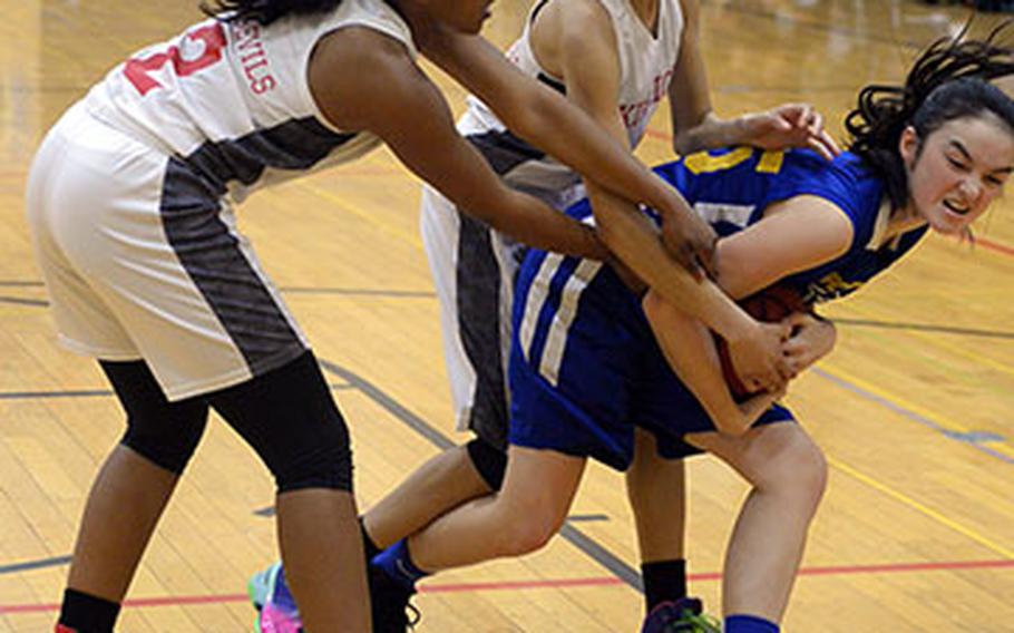 Gimme that ball! Yokota's Emily Taynton tries to keep the ball away from Nile C. Kinnnick's Jade McGinnis and Ernestina Roberts during Thursday's pool play game in the 2nd American School In Japan Kanto Classic Basketball Tournament. The Panther routed the Red Devils 32-11.