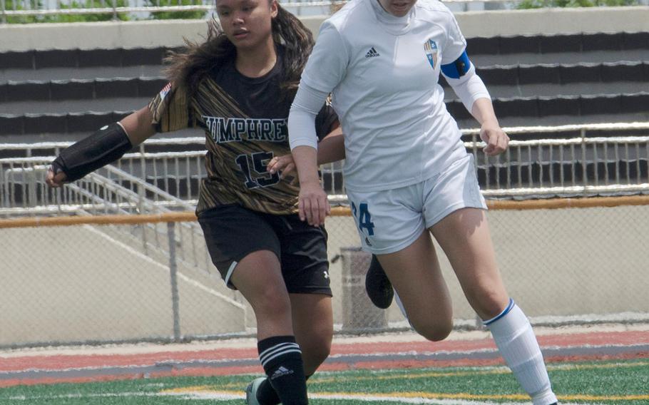 Yokota's Caleigh Garcia and Humphreys' Krystal Duenas battle for the ball during Monday's pool play match in the Far East Division II girls soccer tournament. Garcia scored eight goals in three matches to run her total to 40 this season. Yokota beat Humphreys 3-1.