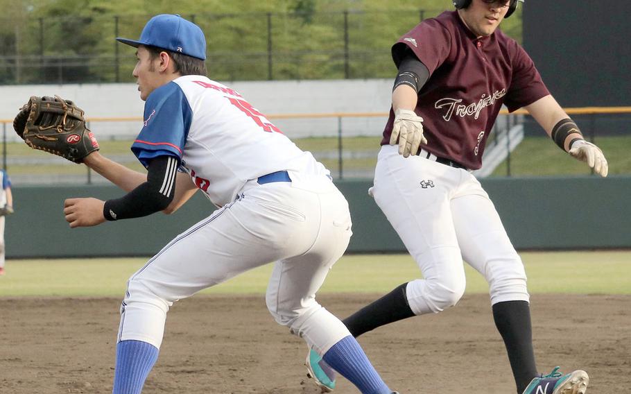 Yokota's Riley DeMarco awaits a throw to first as Zama baserunner Josh Bayardo gets back safely during Tuesday's title game in the Far East Division II baseball tournament. The Panthers routed the Trojans 14-0.