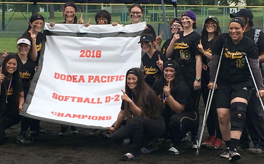 Banner time! Robert D. Edgren players gather round the Far East Division II softball tournament banner after beating Daegu 5-2 in the tournament final.
