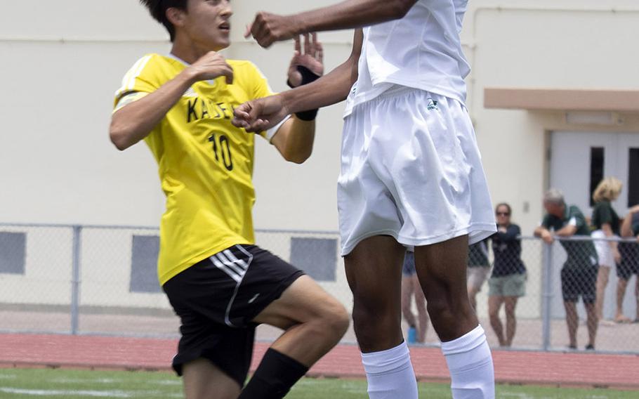 Kubasaki's Ilijah Washington heads the ball over Kadena's Kian Smith during Wednesday's final in the Far East Division I boys soccer tournament. The Dragons pulled away in the second half for a 4-0 win.
