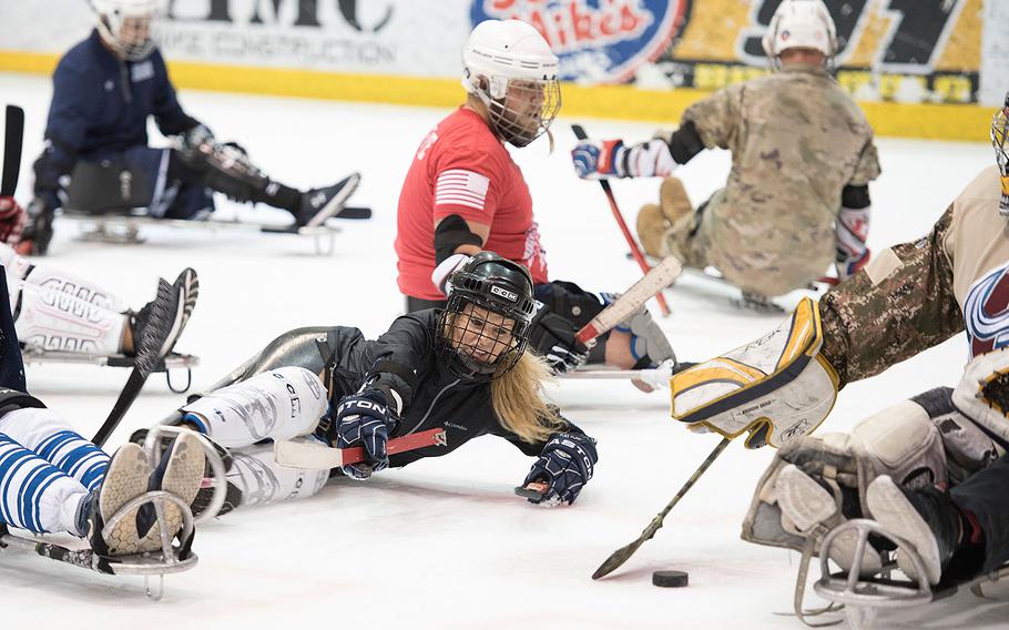 Navy Petty Officer 2nd Class Esther Stevenson looks to score during a pickup game of sled hockey during the 2018 DoD Warrior Games at the U.S. Air Force Academy in Colorado Springs on June 7, 2018.  