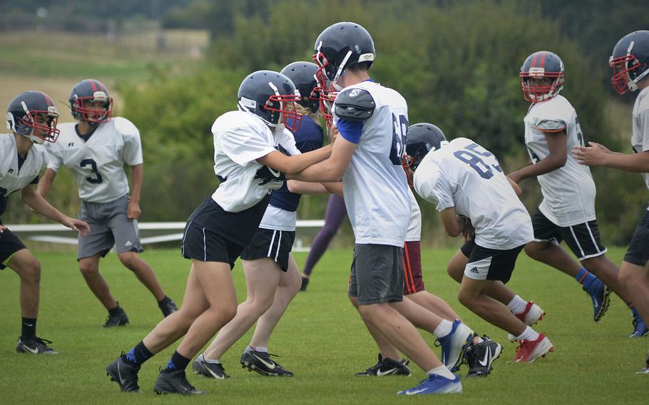 Lancer football players rehearse running plays during an afternoon preseason practice at RAF Lakenheath, England, Tuesday, Aug. 14, 2018.
