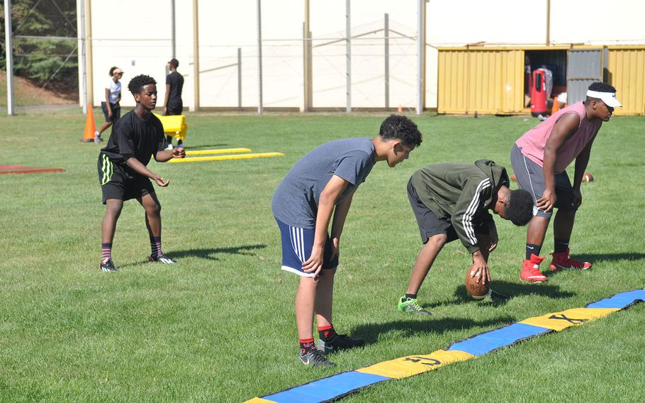 Baumholder players run through a practice snap in a preseason football session at Baumholder High School. The Bucs will play six-man football this fall after years of 11-man ball, requiring coaches and players alike to quickly grasp a new set of rules and strategies. 