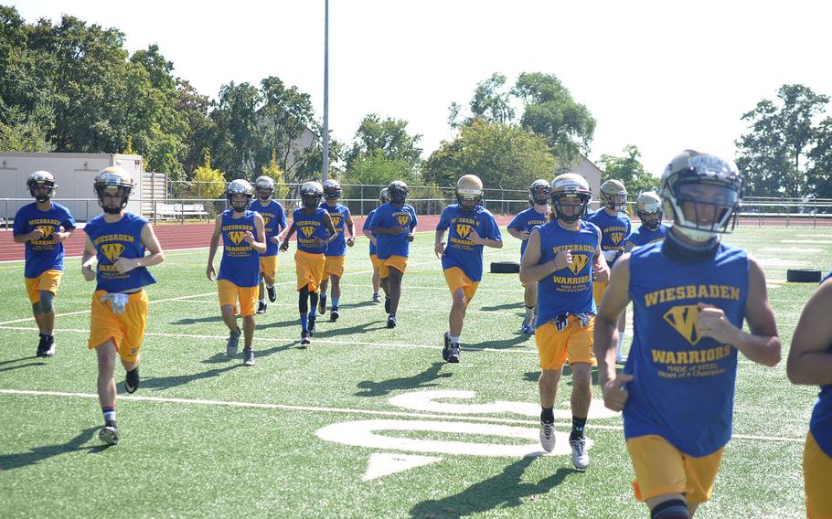 Wiesbaden football players jog off the field for a water break in the midst of a hot August practice session. The Warriors are looking to get back to the European title game after a semifinal loss last season. 