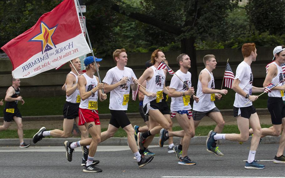 Hunter Jutras carries a flag a flag honoring his older brother Pfc. Dillon Jutras, who was killed in Iraq in 2005, during the Army Ten-Miler in Washington, D.C., Oct. 7, 2018.