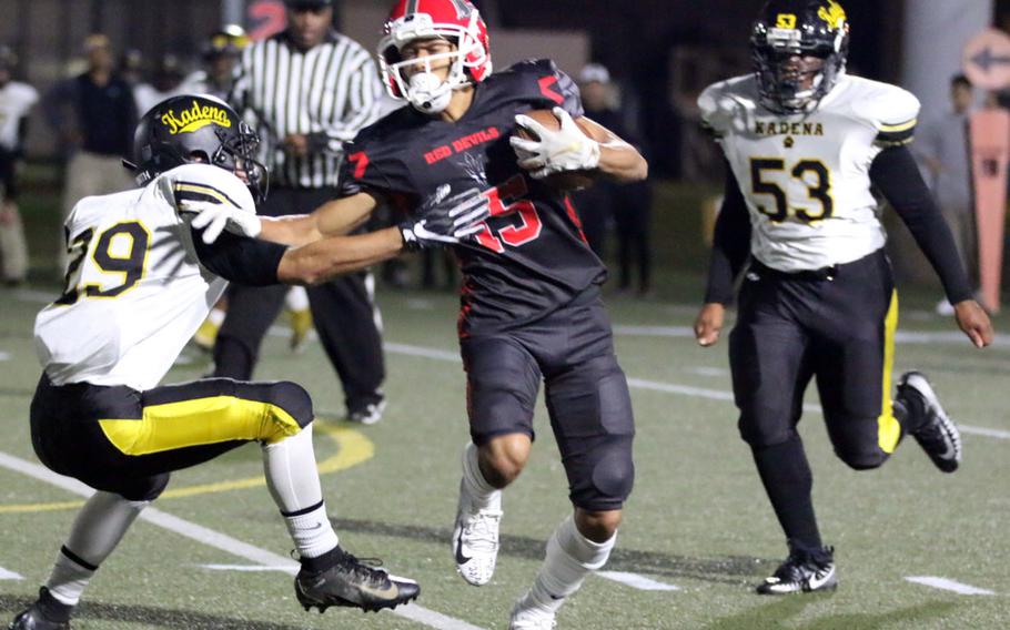 Kinnick receiver Chris Watson knifes between Kadena defenders Trent Fawler and Caleb Wise.