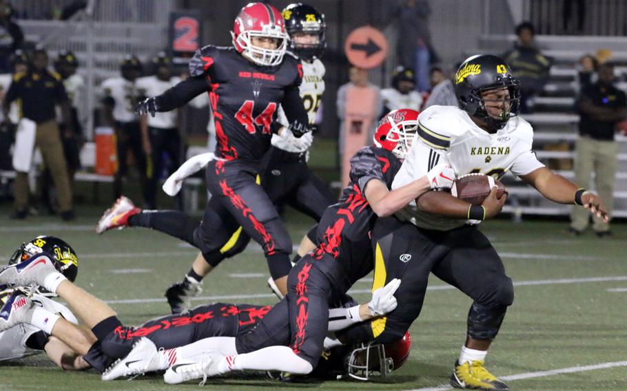 Kadena fullback Uriah Morris drags a couple of Kinnick defenders with him downfield.