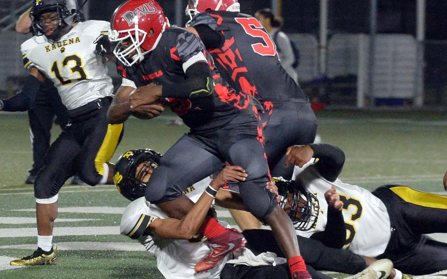 Kinnick running back Travion Morton drags a couple of Kadena defenders downfield.