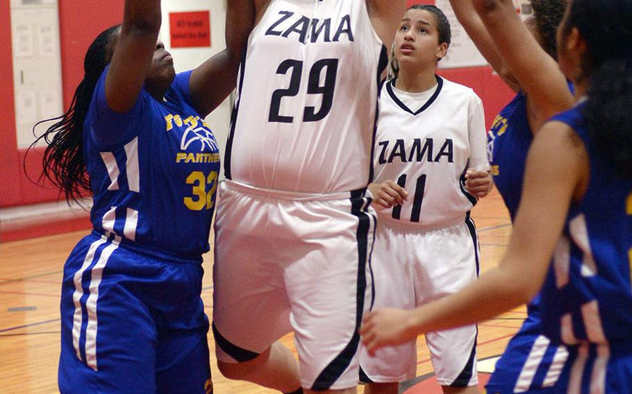 Zama's Jessica Atkinson pulls down a rebound between Yokota's Jaliyah Bailey and Monique Wilson during Friday's DODEA-Japan Tournament championship game. The Trojans won 35-16 to dethrone the four-time defending champion Panthers.