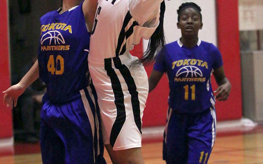 Zama's Jazlyn Rioux reaches back for a rebound behind Yokota defender Keiya Carlson during Friday's DODEA-Japan Tournament championship game. The Trojans won 35-16 to dethrone the four-time defending champion Panthers.