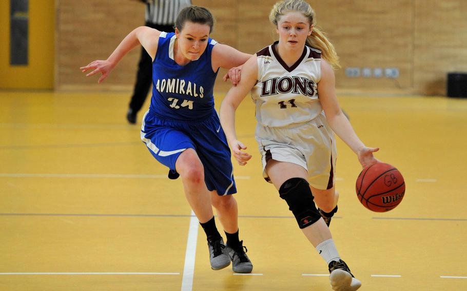 AFNORTH's Victoria Morris drives up the court against Rota's Nina Furner in a Division II game at the DODEA-Europe basketball championships in Wiesbaden, Germany. AFNORTH won 30-18.