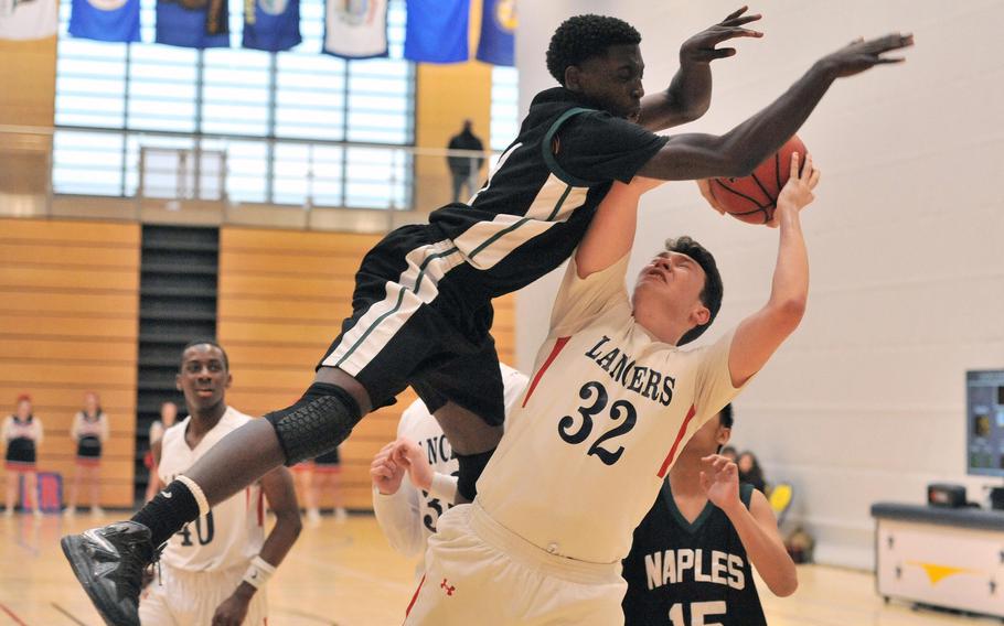 Naples' Tye Thompson leaps high to defend against Lakenheath's Daniel Uelman in a Division III game at the DODEA-Europe basketball championships in Wiesbaden, Germany. Thompson was called for a foul and the Lancers went on to beat the Wildcats 51-44.