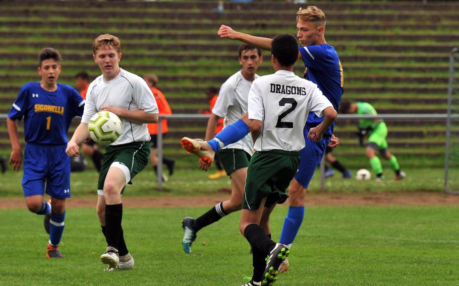 Sigonella's David Spencer shoots and scores past Alconbury's Cameron Rowley, left, and Ty Palacios in Sigonella's 7-0 win over the Dragons in a Division III game at the DODEA-Europe soccer finals in Landstuhl, Monday, May 20, 2019. 









