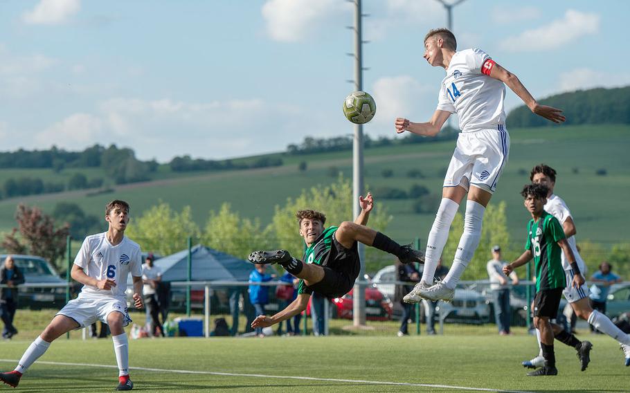 Naples' Christian Albright goes for a scissor kick on goal as Wiesbaden's Anthony Hall jumped for a header during a Division I semifinal game on the third day of the DODEA-Europe soccer championships, Wednesday, May 22, 2019.