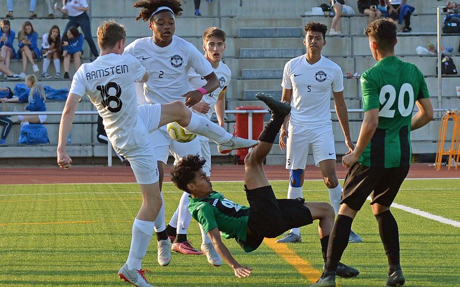 Naples' Wutthipong Khotsaeng attempts a scissors kick against Ramstein's Benjamin Brewster and Jerrell Brevard, as Gavin McMillan, Noah Yancy and Chase Traylor, from left, watch. Naples defeated Ramstein 1-0    in the boys Division I final at the DODEA-Europe championships in Kaiserslautern, Germany.