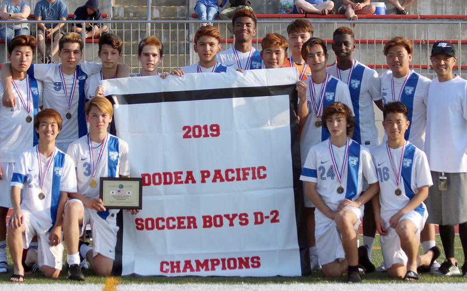 CAJ players and coach gather round the championship banner.