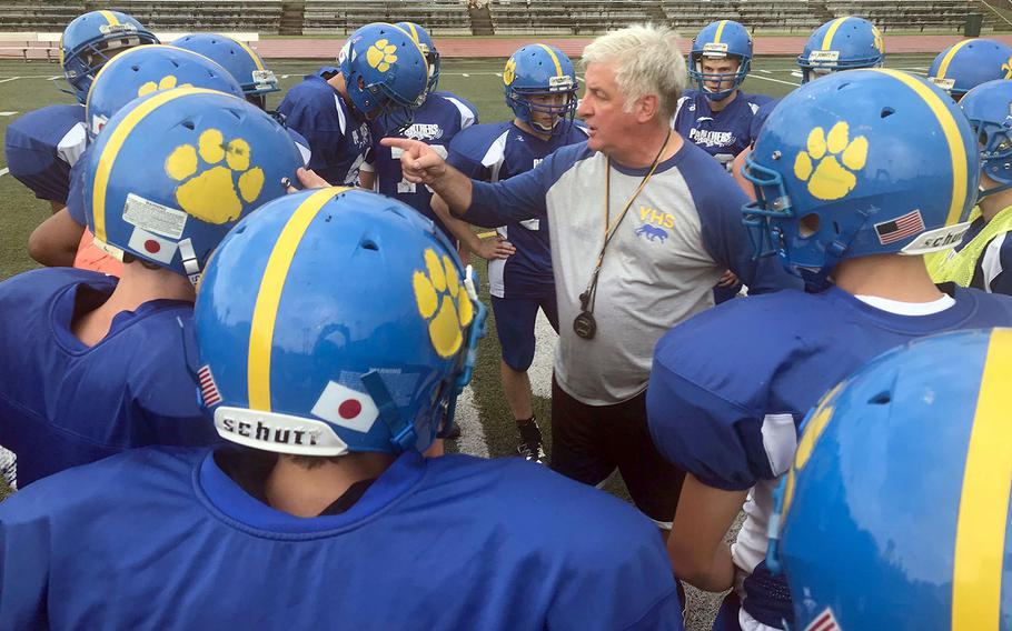 Tim Pujol, in his 21st year of coaching at Yokota, makes a point during a Panthers practice huddle.
