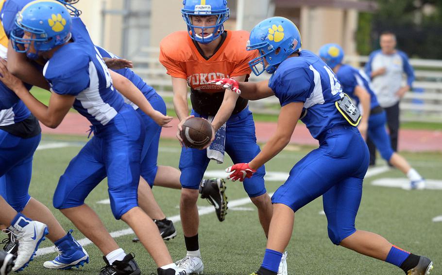 Returning Yokota running back Joey DeGrella follows blocks into the line as he takes a handoff from Chris Jones, the Panthers' new quarterback via Nebraska.