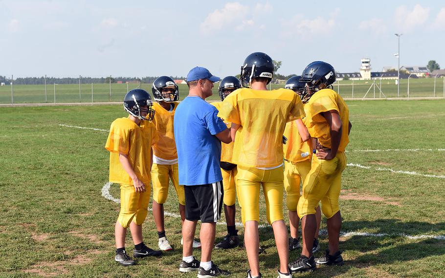 The Ansbach Cougars huddle with assistant coach Bryan Osewalt on Tuesday, Aug. 27, 2019,  at Ansbach High School.