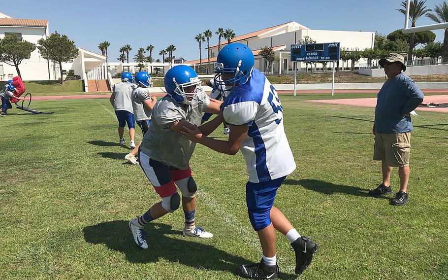 Rota assistant coach Ken Walter supervises a blocking drill at a preseason practice session at Naval Station Rota, Spain.