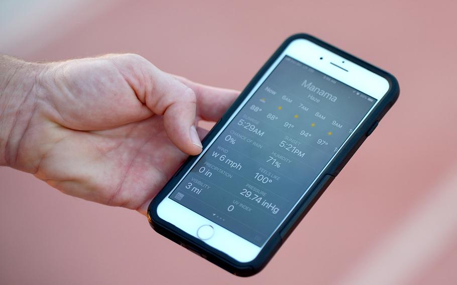 Coach Josh Dinkler checks the temperature in Bahrain on Thursday, Oct. 3, 2019.. The team trains early in the mornings in the school hallways to avoid heat-related injuries. 